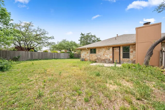 a view of a house with backyard and a tree