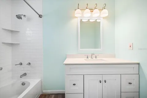 a bathroom with a sink bath tub and a mirror