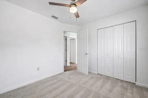 a view of an empty room and chandelier fan