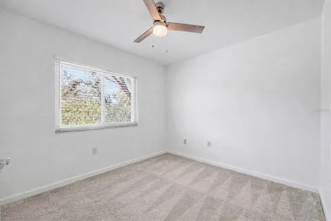 an empty room with a window and a ceiling fan