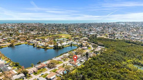 an aerial view of ocean and residential houses with outdoor space