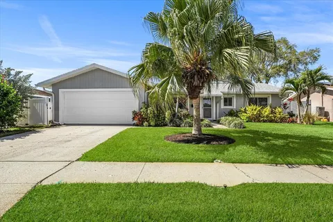 a front view of a house with a garden and tree