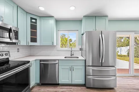 a kitchen with stainless steel appliances a refrigerator sink and microwave