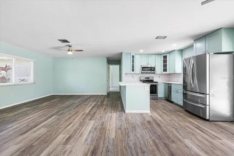 a kitchen with stainless steel appliances a refrigerator and wooden floor