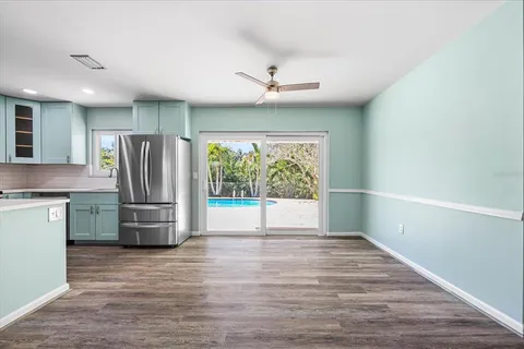 a view of kitchen with stainless steel appliances granite countertop a refrigerator and a stove top oven