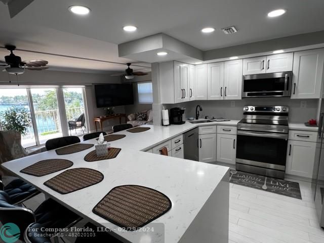 a kitchen with sink a microwave a stove and refrigerator