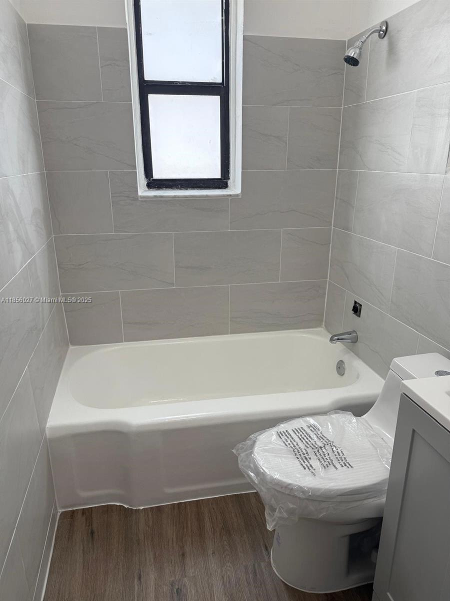 1432 Northeast 163rd Street, Unit 2 North Miami Beach, FL 33162 - Photo 14 of 18 a bathroom with a bathtub and window