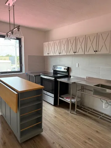 an empty room with wooden floor and ceiling fan