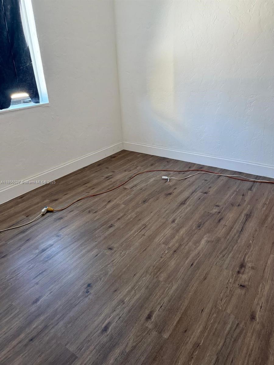 1432 Northeast 163rd Street, Unit 2 North Miami Beach, FL 33162 - Photo 6 of 18 a view of room with wooden floor and cabinet