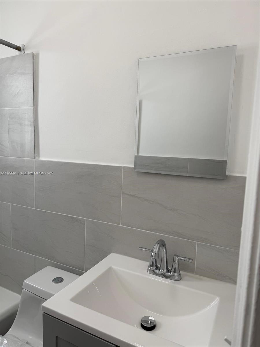 1432 Northeast 163rd Street, Unit 2 North Miami Beach, FL 33162 - Photo 7 of 18 a bathroom with a sink and a tub