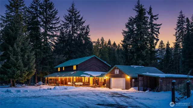 a view of a house with wooden deck and trees around