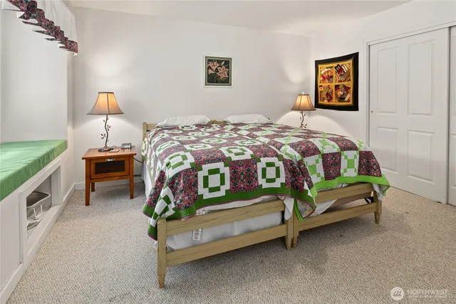 a bedroom with a bed and a lamp on the dresser