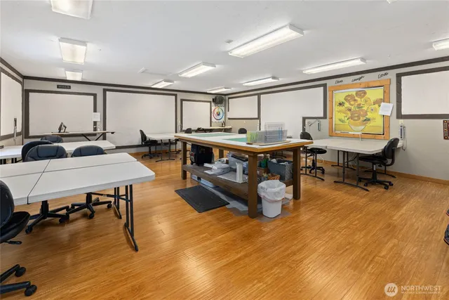 a living room with furniture pool table and wooden floor