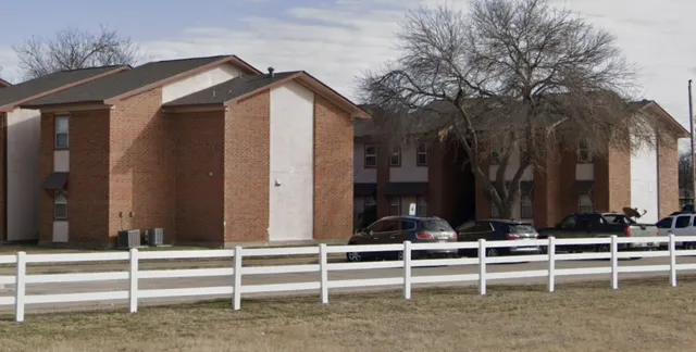 a view of a house with a yard and large tree