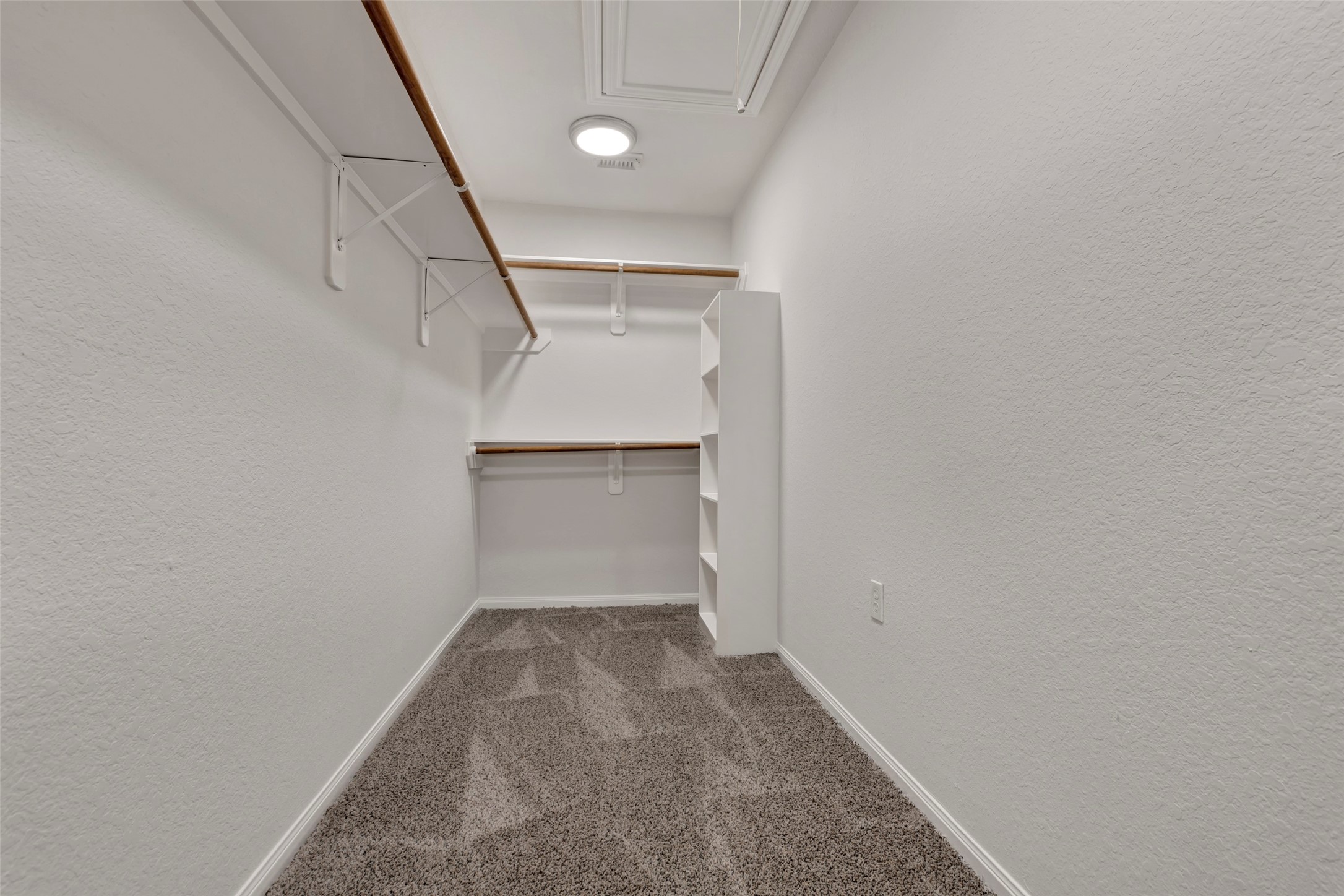 770 Hunt Road, Unit 212 Baytown, TX 77521 - Photo 36 of 40 This is a spacious walk-in closet featuring ample shelving and hanging space, with a plush carpeted floor and well-lit ceiling, ideal for clothing and storage organization.
