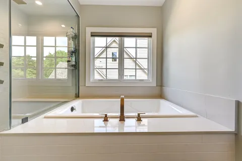 a bathroom with a tub and a large window