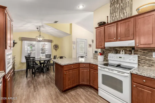 a kitchen with a sink stove cabinets and wooden floor