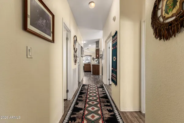 a view of a hallway with wooden floor and staircase
