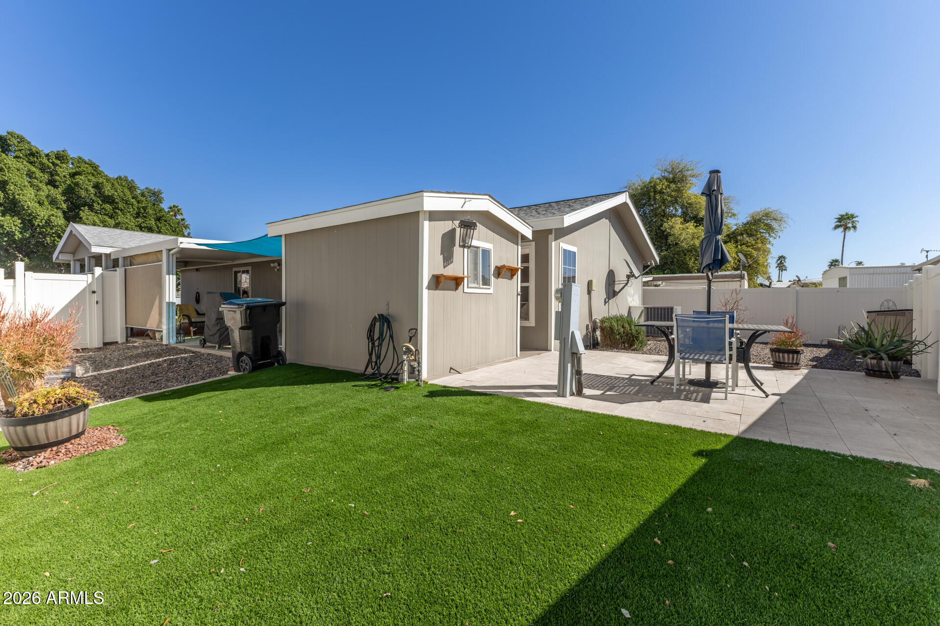 201 South Greenfield Road, Unit 124 Mesa, AZ 85206 - Photo 22 of 31 a front view of a house with a garden and patio