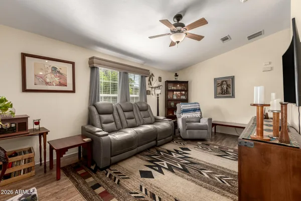 a living room with furniture ceiling fan and a window
