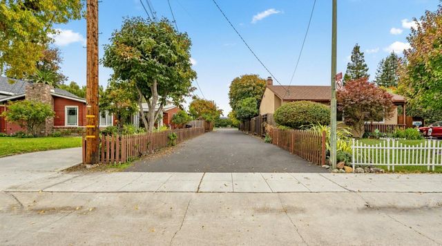 a view of a house with a big yard and large trees