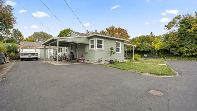a front view of a house with a yard and potted plants