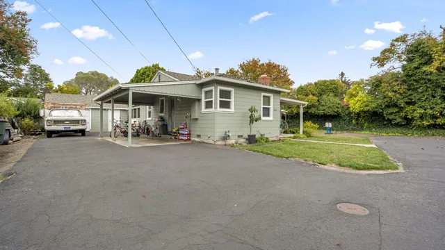 a front view of a house with a yard and potted plants