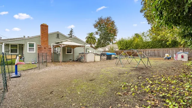 a view of a house with a yard and potted plants