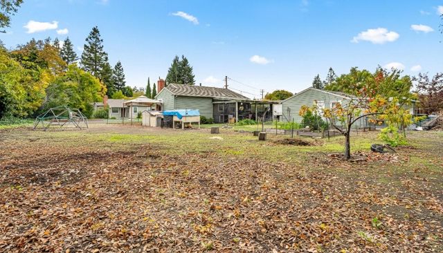 a view of a house with backyard and a tree