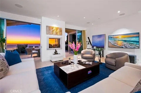 a living room with furniture large windows and a fireplace