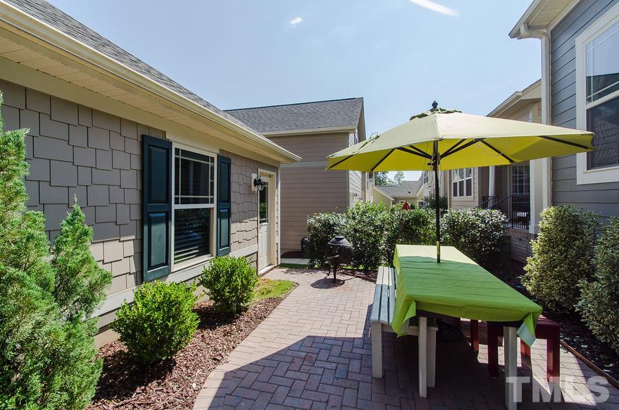 1407 Van Page Boulevard Raleigh, NC 27607 - Photo 22 of 25 a view of a house with table and chairs under an umbrella