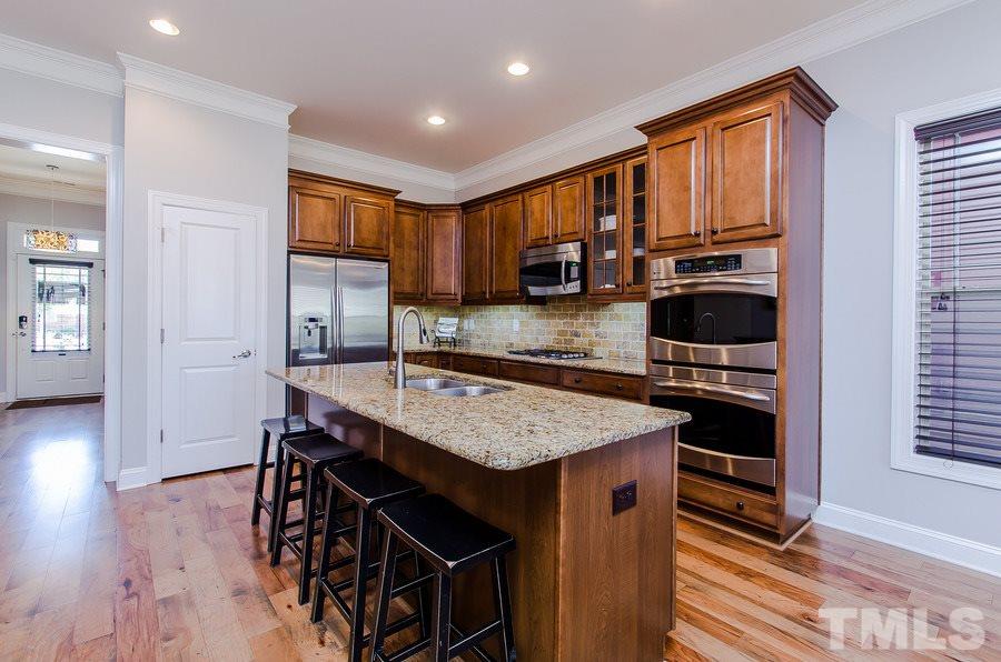 1407 Van Page Boulevard Raleigh, NC 27607 - Photo 9 of 25 a kitchen with stainless steel appliances granite countertop a stove top oven a sink dishwasher and a refrigerator with wooden floor