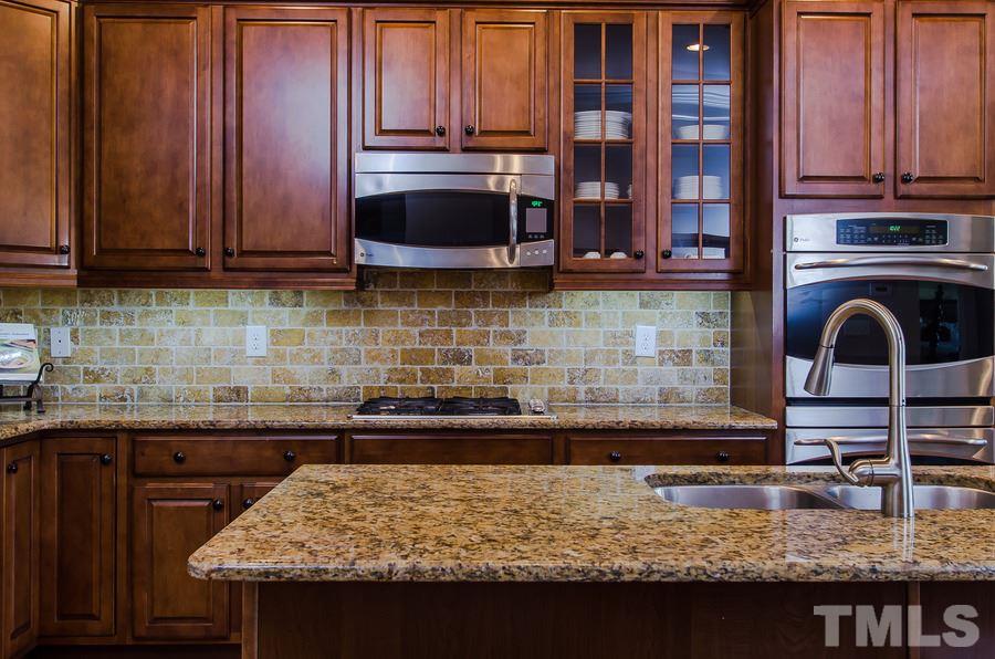 1407 Van Page Boulevard Raleigh, NC 27607 - Photo 10 of 25 a kitchen with granite countertop wooden cabinets and a granite counter tops