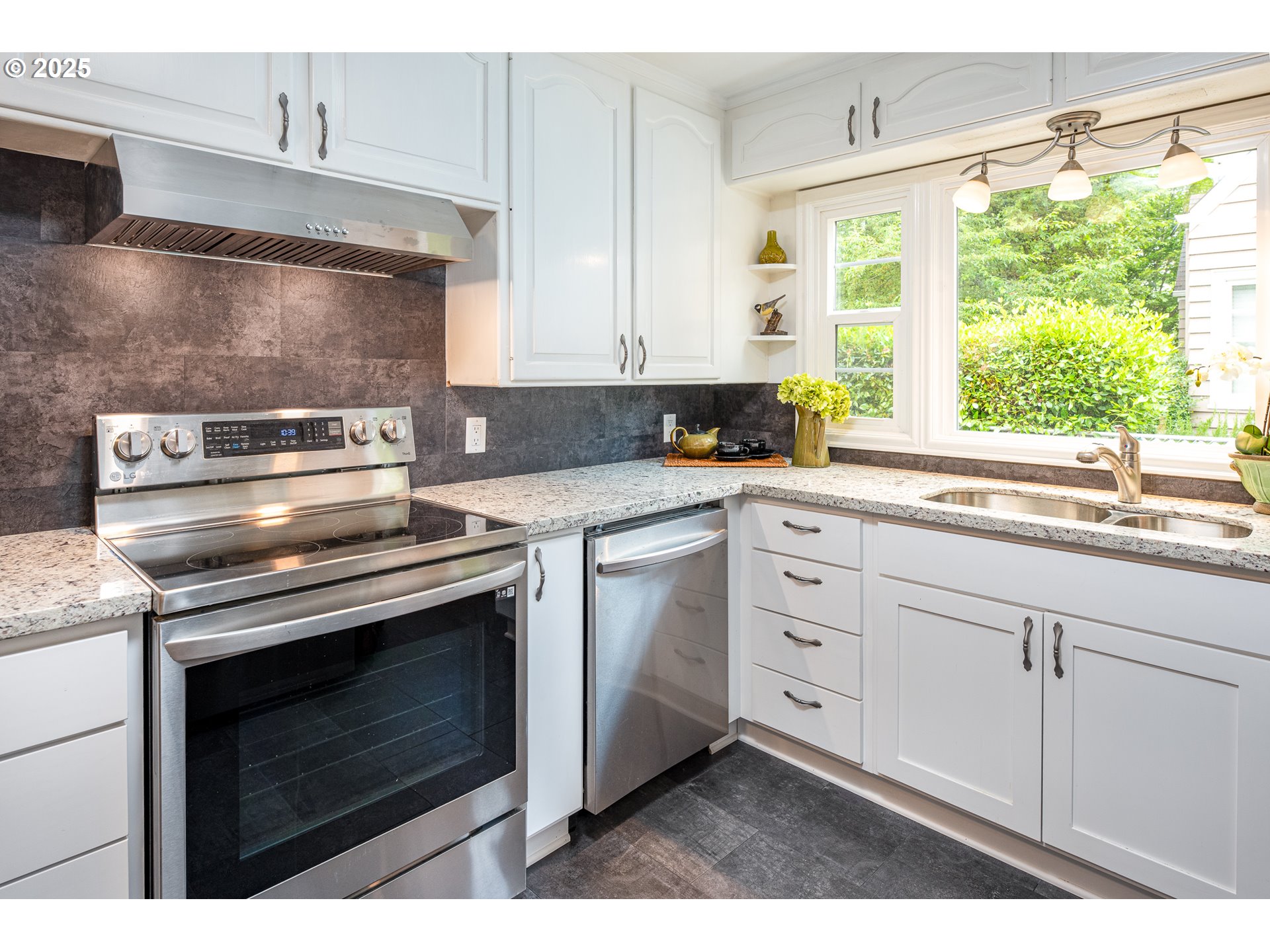 1624 Washington Street Eugene, OR 97401 - Photo 15 of 41 a kitchen with white cabinets appliances and a sink