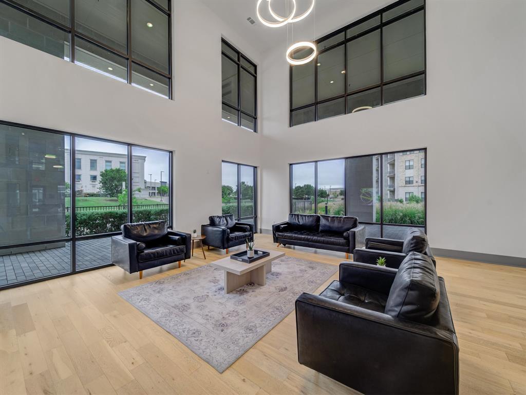 2700 Old Denton Road, Unit 2212 Carrollton, TX 75007 - Photo 28 of 38 Soaring ceilings with tall windows, natural wood-finish flooring, recessed lighting, and modern pendant light fixtures