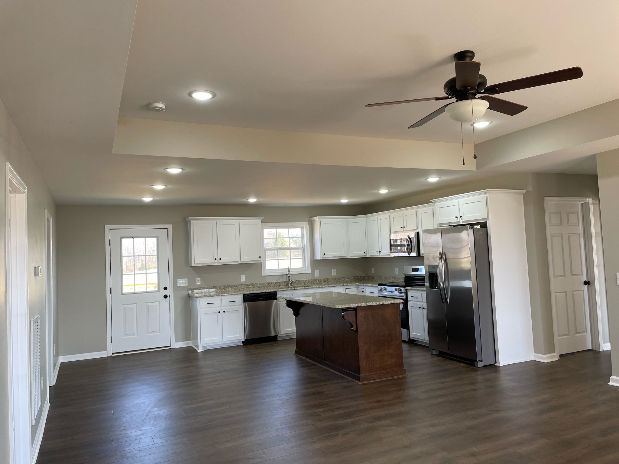 1185 Coleytown Road Lafayette, TN 37083 - Photo 7 of 20 a kitchen with stainless steel appliances granite countertop a refrigerator a sink dishwasher a stove and white cabinets with wooden floor