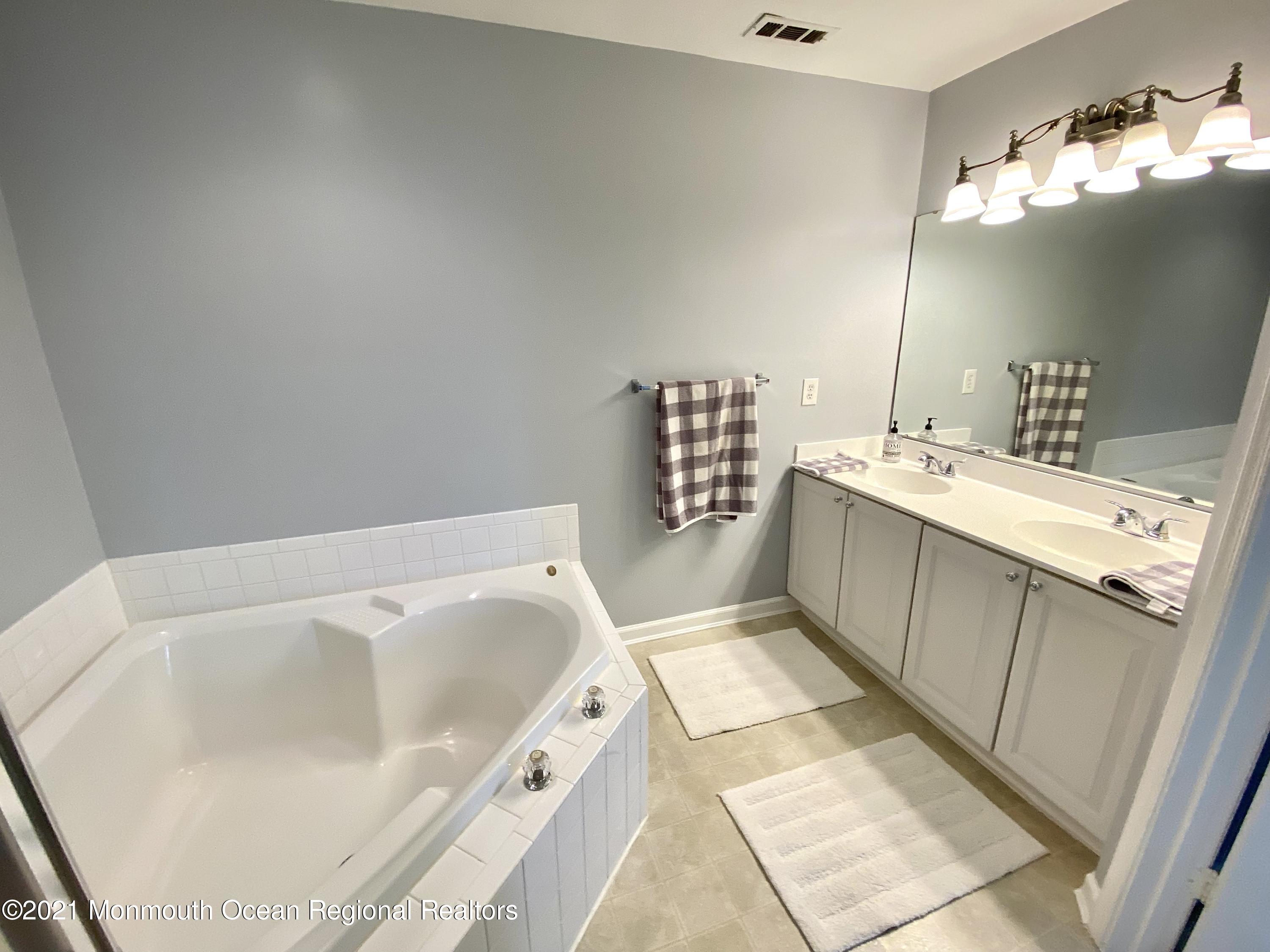 3 Skimmer Lane, Unit 38 Bayville, NJ 08721 - Photo 20 of 22 a bathroom with a tub sink and mirror