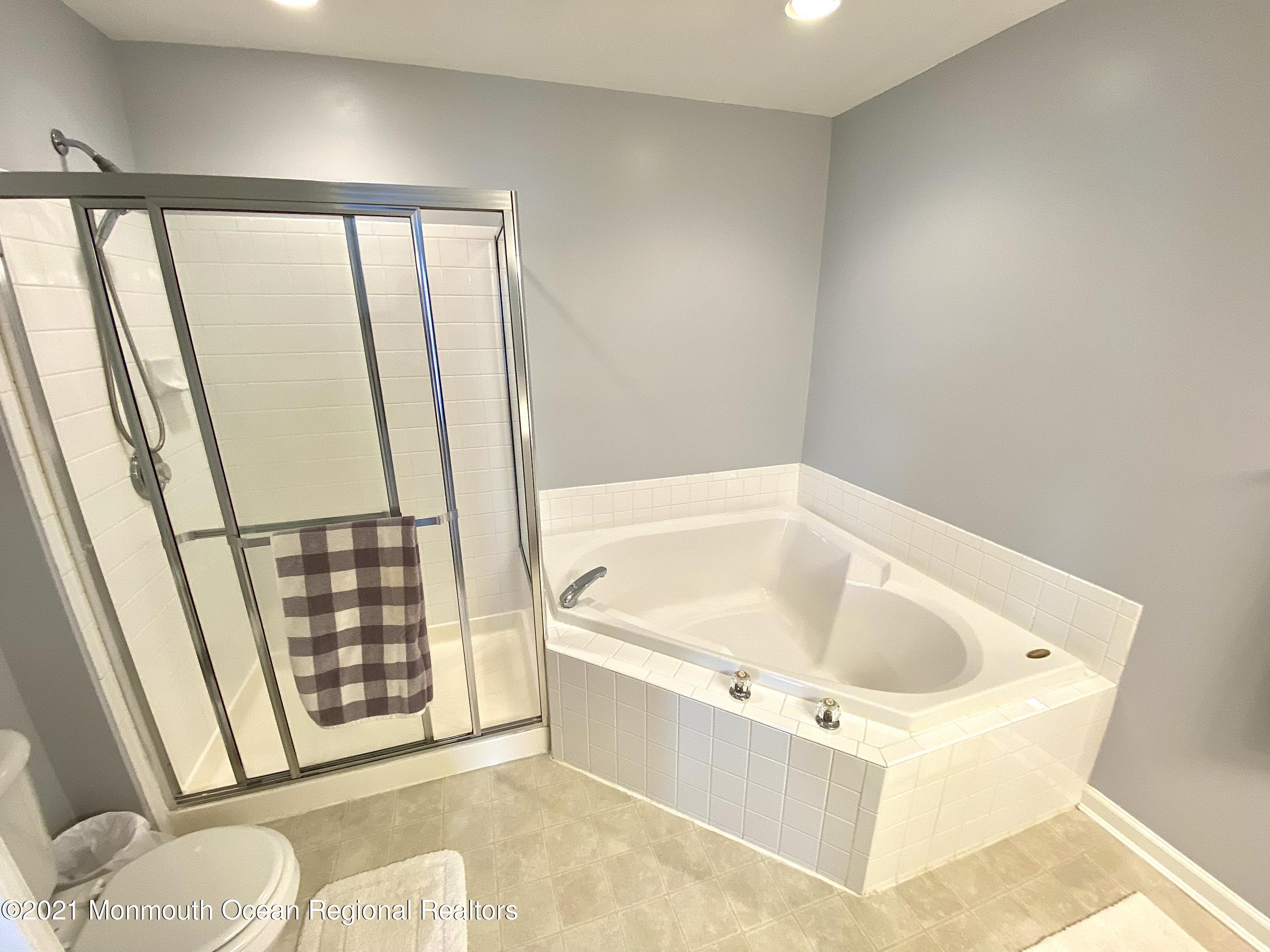 3 Skimmer Lane, Unit 38 Bayville, NJ 08721 - Photo 21 of 22 a white bath tub sitting next to a toilet