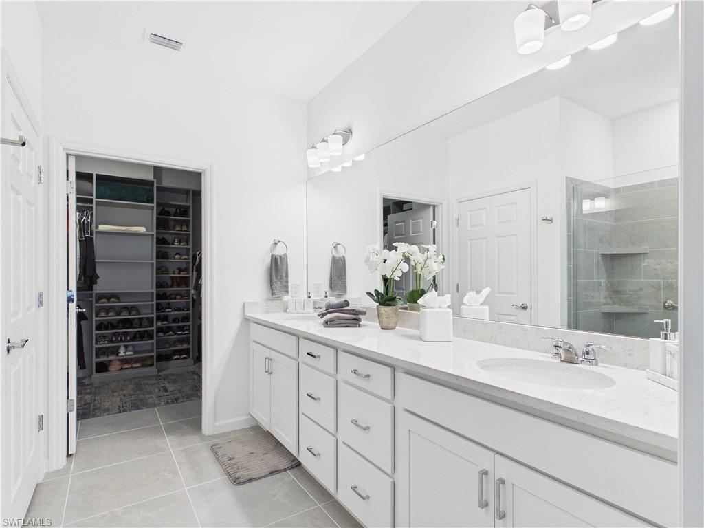 5683 Mayflower Way, Unit 908 Ave Maria, FL 34142 - Photo 25 of 37 Bathroom featuring double vanity, a stall shower, light tile patterned floors, and a spacious closet