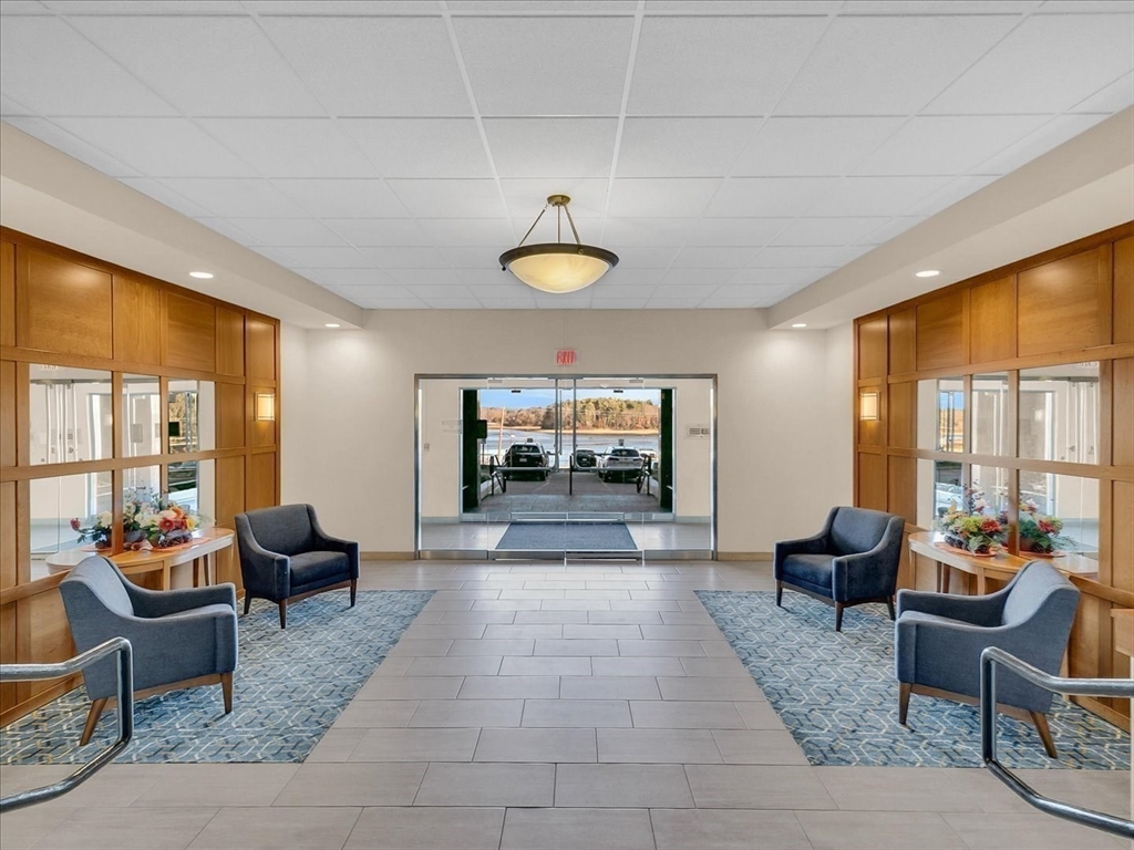 1500 Worcester Road, Unit 221 Framingham, MA 01702 - Photo 22 of 34 a living room with furniture a chandelier and a large window