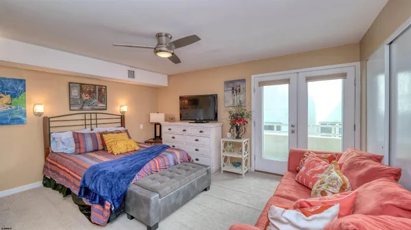 a spacious bedroom with a bed and flat screen tv