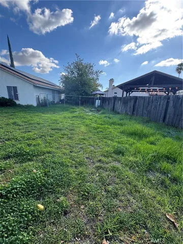 a view of a backyard with potted plants and wooden fence