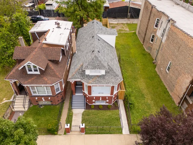 an aerial view of a house with garden space and building view