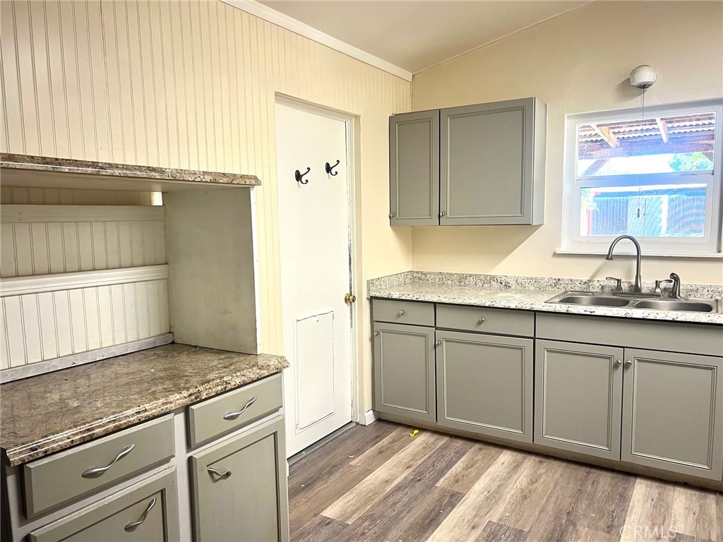 1550 Primrose Avenue Merced, CA 95340 - Photo 15 of 46 a kitchen with granite countertop a sink cabinets and a wooden floor