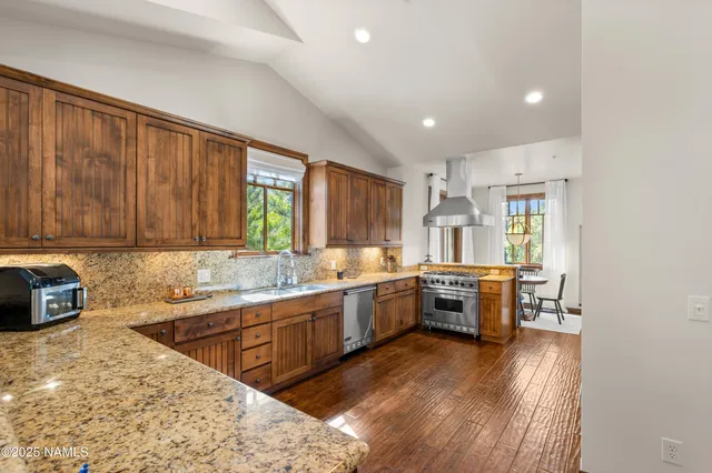 a kitchen with stainless steel appliances granite countertop a sink stove and refrigerator