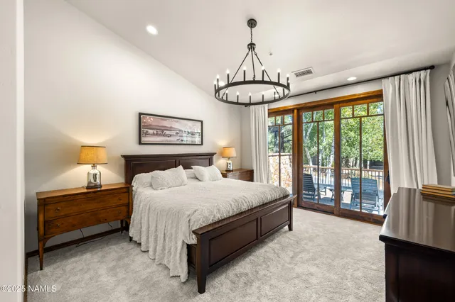 a bedroom with bed and a chandelier