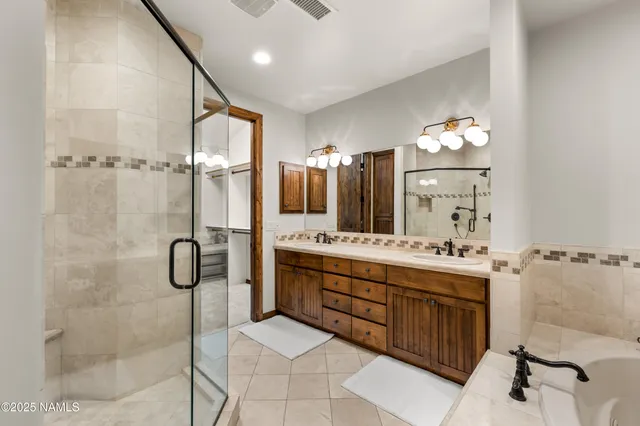 a bathroom with a tub sink shower and mirror