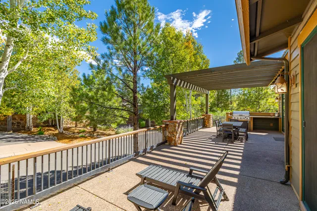 a view of a patio with table and chairs potted plants with wooden floor and fence