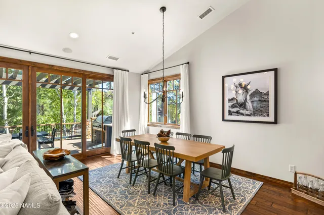 a view of a a dining room with furniture window and wooden floor