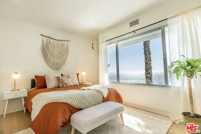 a bedroom with a bed and a potted plant